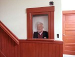 A picture of Chet Briggs in the historic ticket window newly reinstalled in the restored front entrance hallway